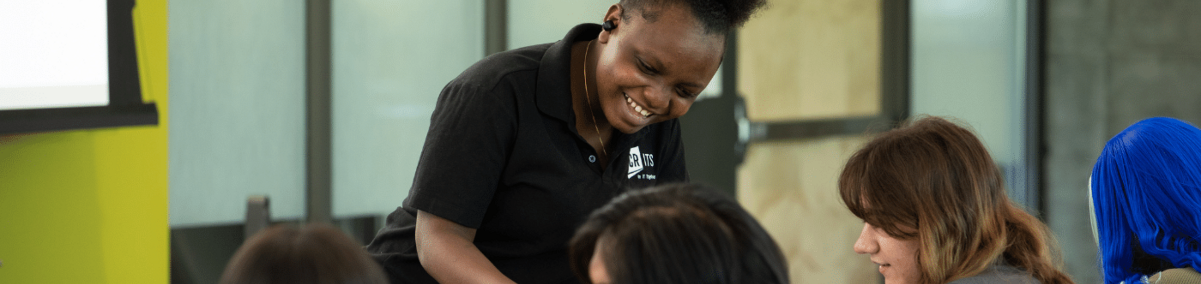 staff member helps other students in classroom