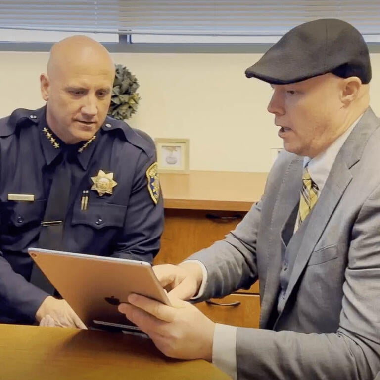 Police officer & ITS worker look at tablet