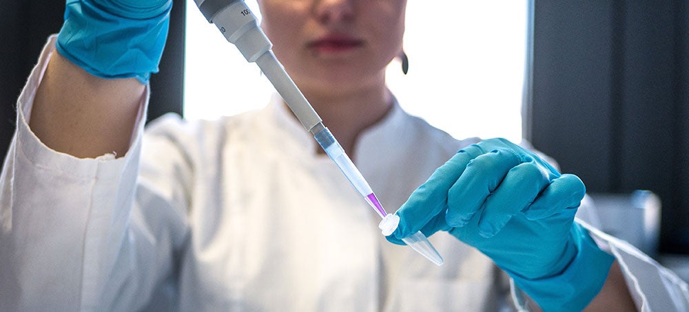 student in the lab with pippet (c) Julia Koblitz unsplash