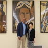 Congressman Shomari Figures and Mihoko Hosoi standing in front of three large paintings of Tuskegee Airmen.