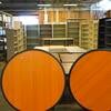 Circular wooden rolling tables with wooden desks and metal bookcases in background