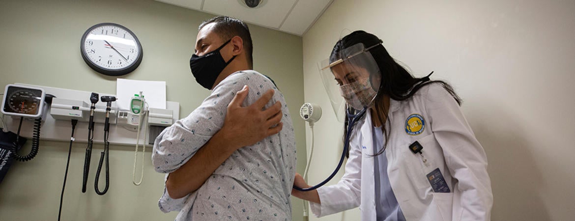 A medical student listening to the heartbeat of a standardized patient