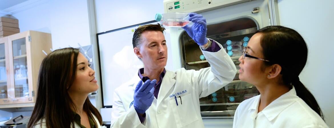 Declan McCole in the lab with two graduate students