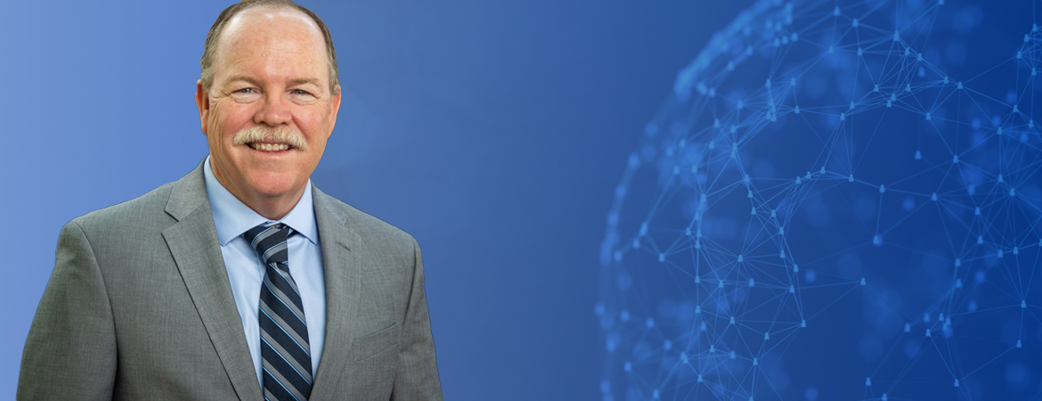 Tim Collins in front of a globe