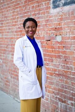 Dr. Adwoa Osei in front of a brick wall
