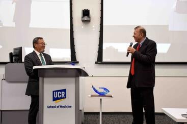 Dr. Thomas Haider presenting Dr. Lo with a plaque at the 2025 Haider Lecture