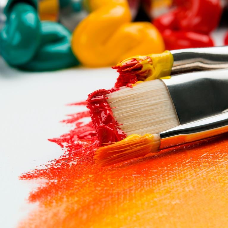 paint brushes laying on side dipped in paint