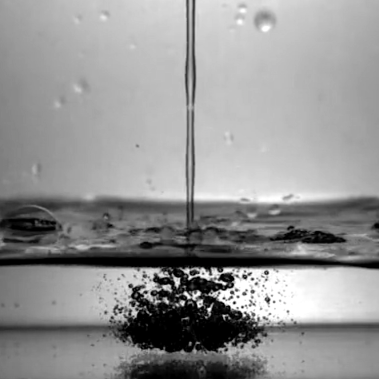 A stream of mezcal making bubbles in a bowl