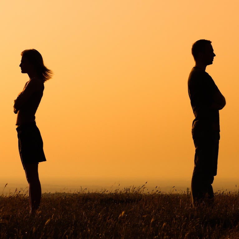 A couple facing away from each other at sunset