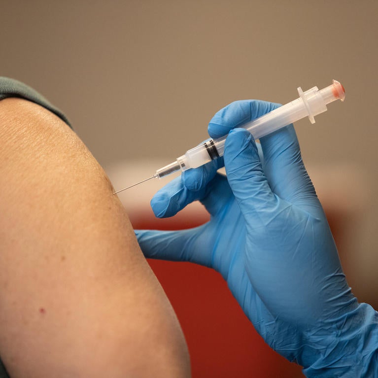 A person's arm is shown getting the vaccine