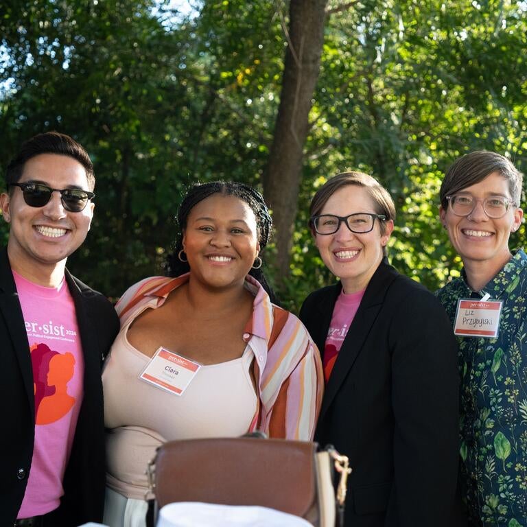 A group of four people smiling