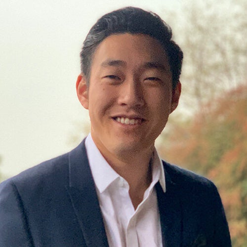 UCR chemistry professor, Timothy Su, smiles in front of a tree-lined background.