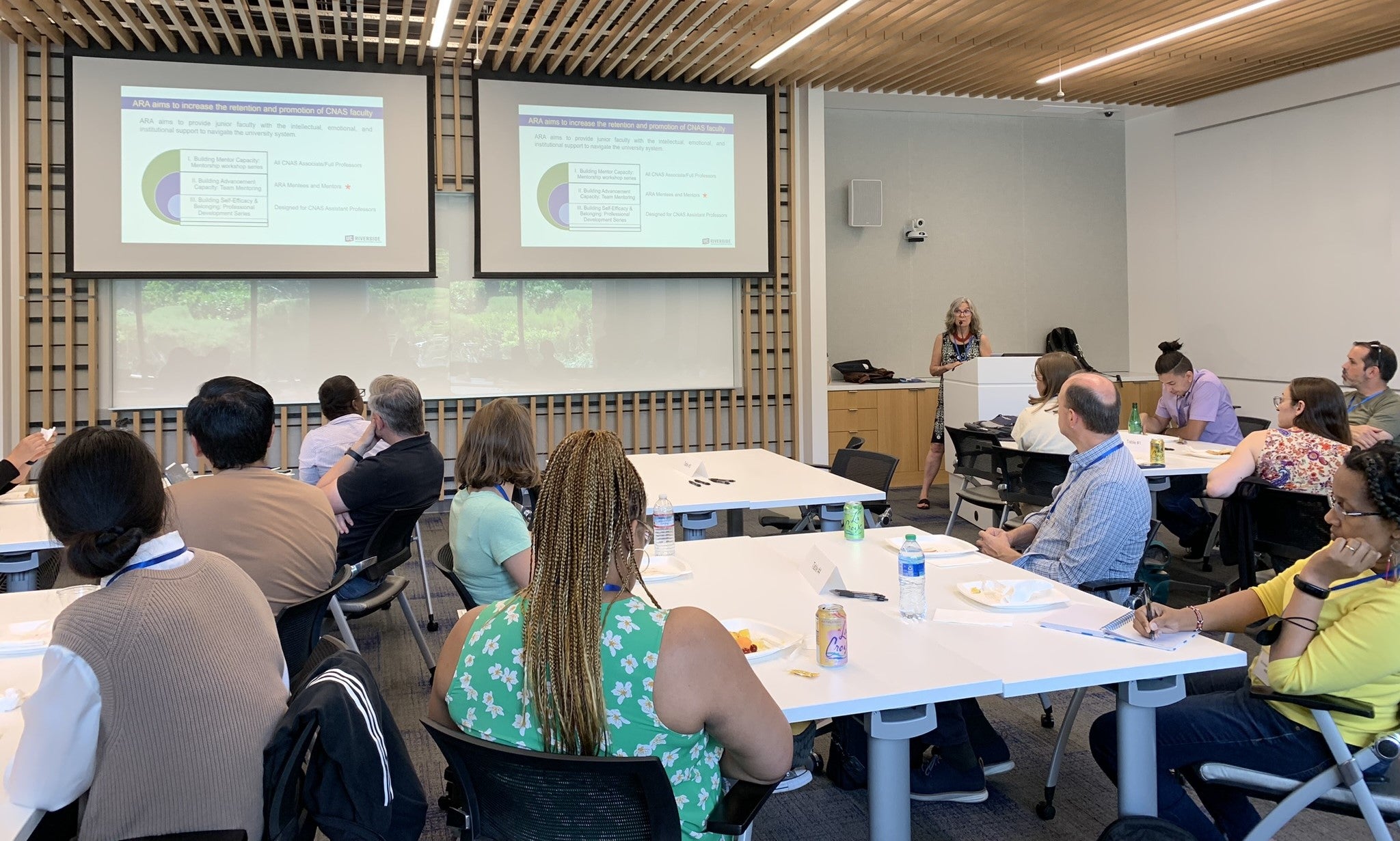 people sitting at tables listening to a presentation