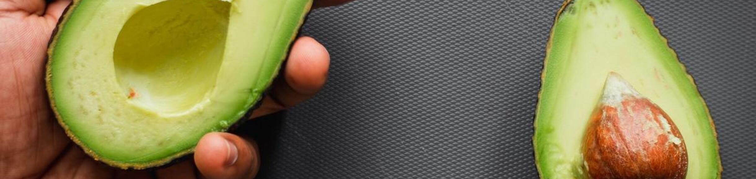 hand holding avocado half (c) Louis Hansel
