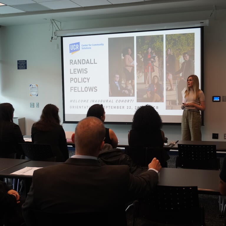 A class of fellows sitting in front of a projector
