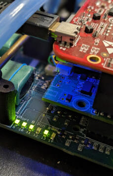 A close-up view of a circuit board with various electronic components illuminated by blue and green lights.
