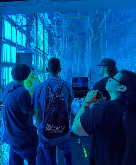 A CE-CERT graduate student explains the Atmospheric Processes Laboratory to high school students, highlighting research on air pollutant interactions