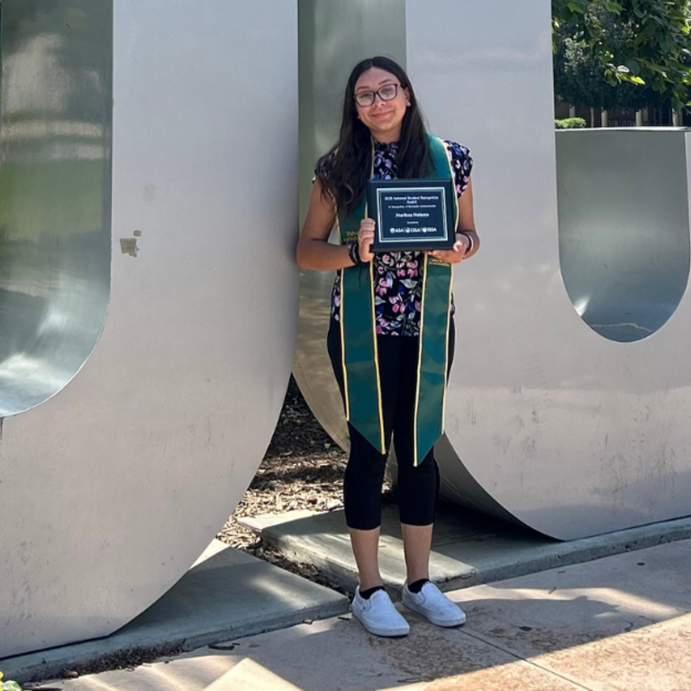CNAS student standing by UCR sign