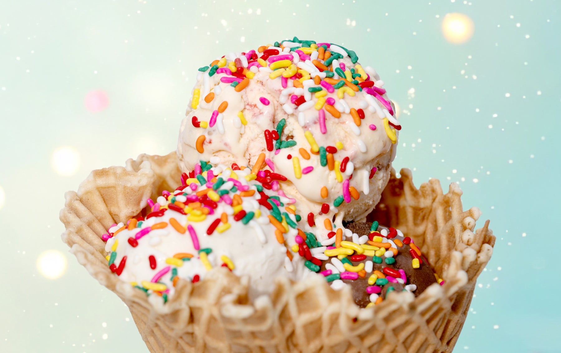 three scoop ice cream in cone with sprinkles