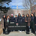 Women In Computing members standing with a banner during travel