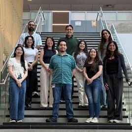 Group of student researchers and faculty posing on stairs 