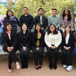 student mentors and professional staff in business attire posing outdoors