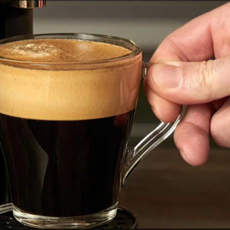 Espresso coffee in a clear glass cup.