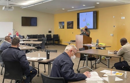 People in classroom studying forklift material.