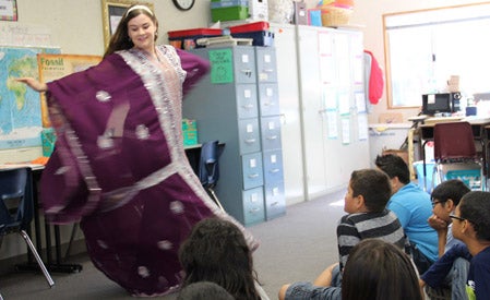 female in traditional Egyptian dress demonstrating a dance for students