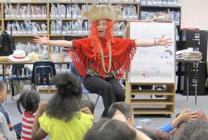 female story teller sitting in front of a group of students