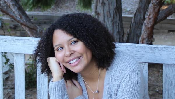 Tyler smiling, sitting on a bench