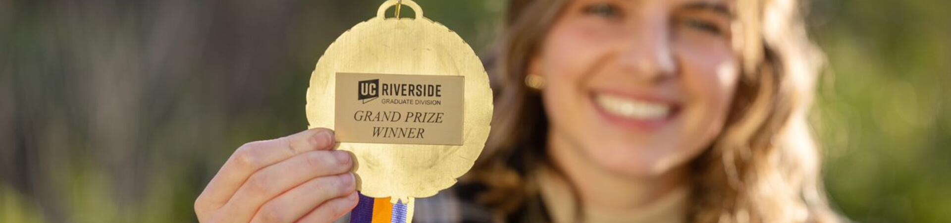 Elissa Monteiro holds her UCR Grad Slam Winner Medal