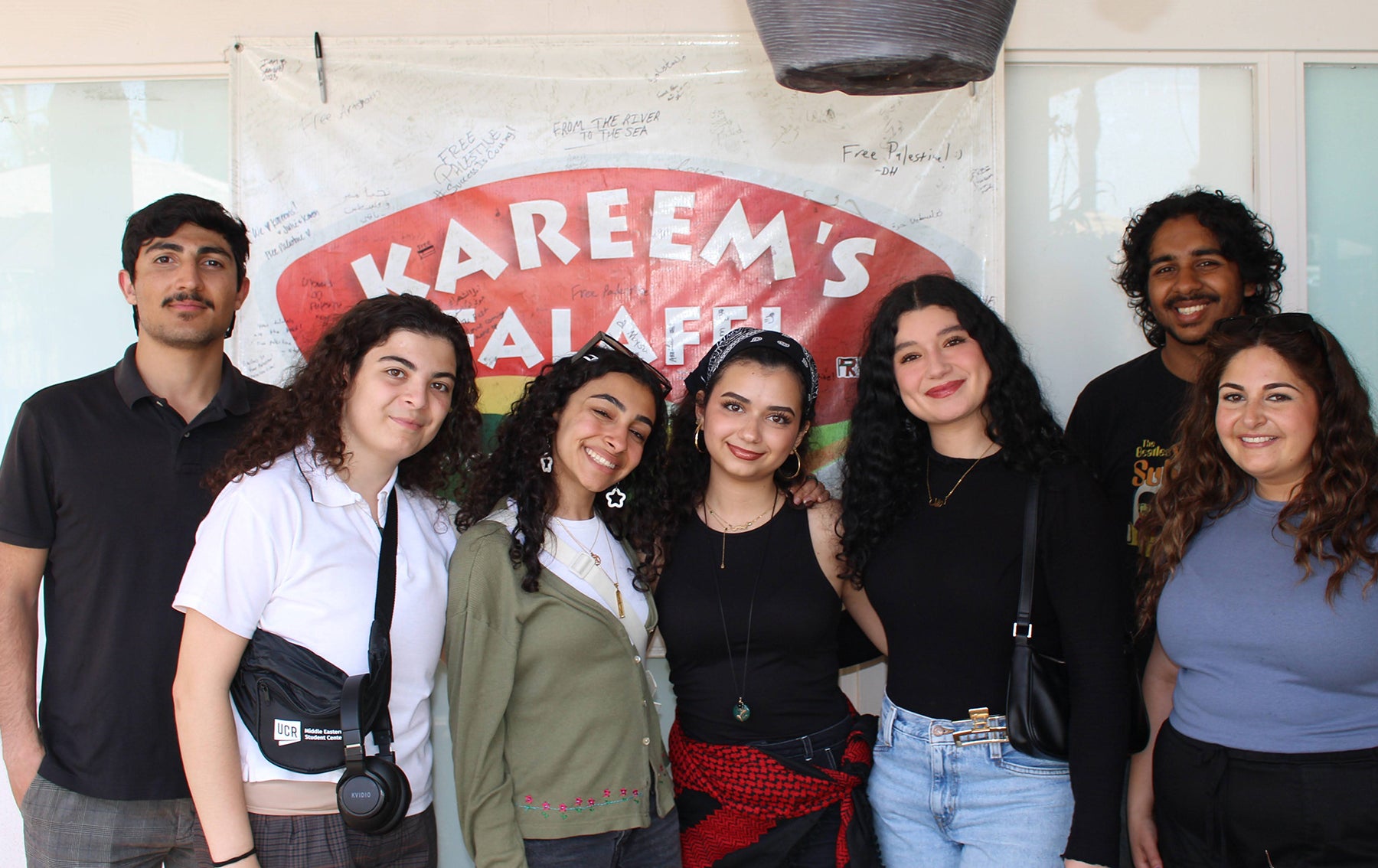 students in front of kareem's falafel sign