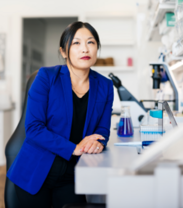 woman sitting next to microscopes
