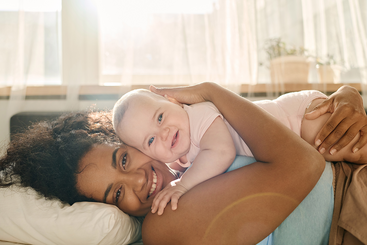 Mom laying down holding her baby