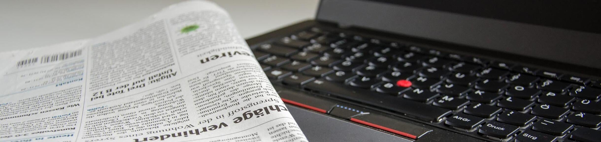 Newspaper and laptop close-up