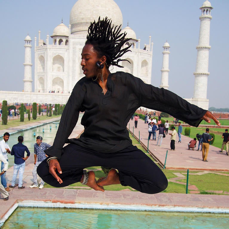 Male UCR student jumping in front of the Taj Mahal