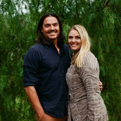 Alumni couple Andy ’94 & Keri ’94 stand in front of greenery