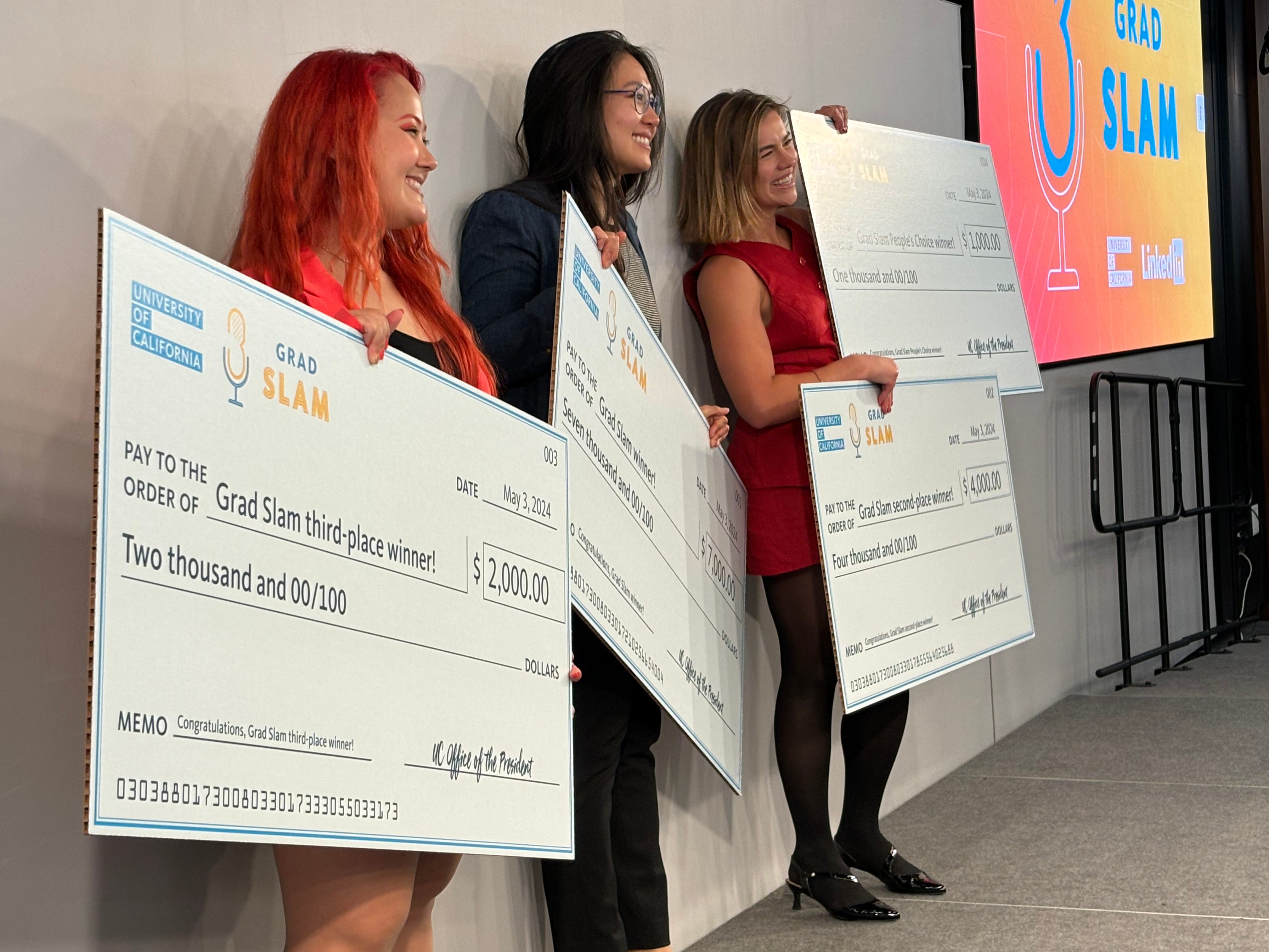 UC Grad Slam winners holding giant award checks