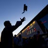 BCOE graduate tossing cap in front of Toyota Arena