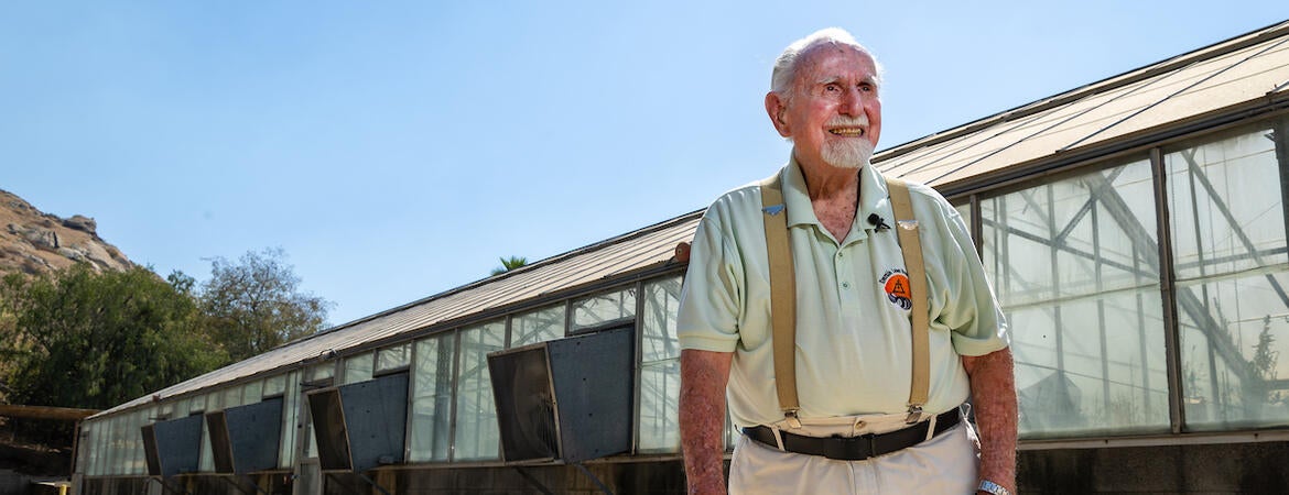 Jerry Ervin in front of greenhouse