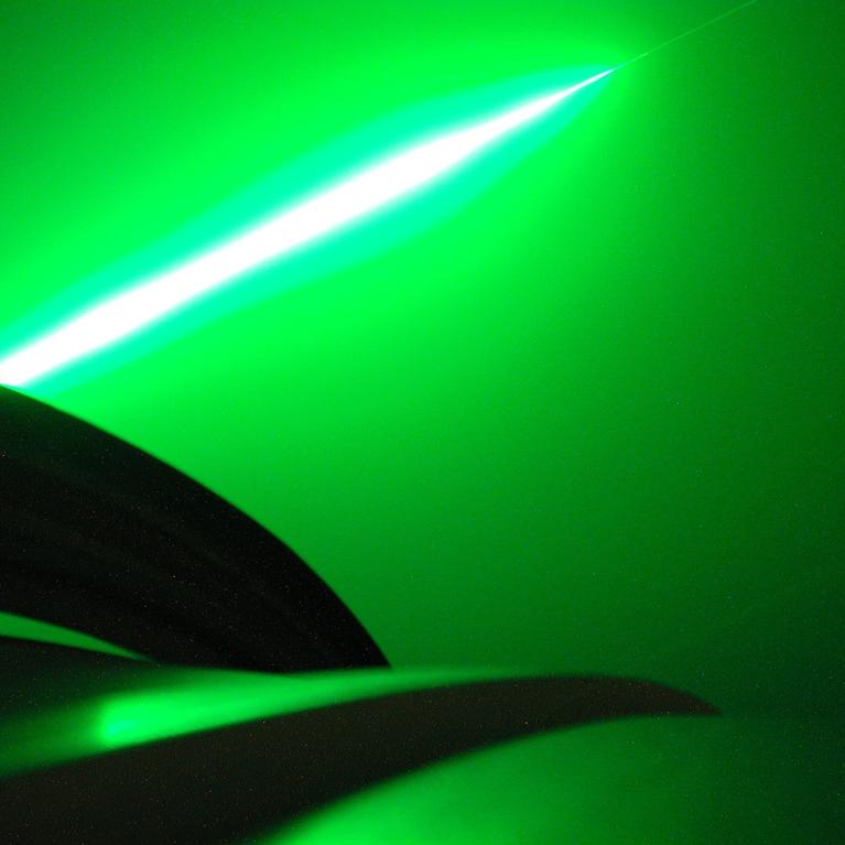 The brilliant green beam of the lidar at the Mauna Loa Observatory (MLO) measures aerosols and water vapor high in the stratosphere. This unretouched image was made when fog briefly formed during an observing session. The camera The camera was leaned against the side of the dome that houses the Dobson spectroradiometer that measures the ozone layer. Hawaii, Mauna Loa.