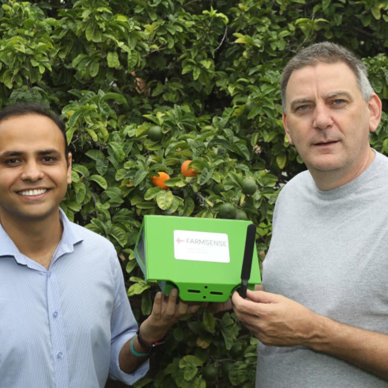 Shailendra Singh (left) and Eamonn Keogh (right) hold a FarmSense FlightSensor insect trap