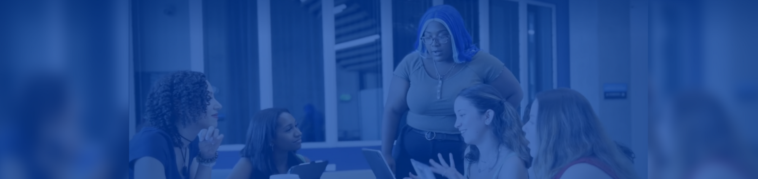 engaged happy students gather around a tablet 
