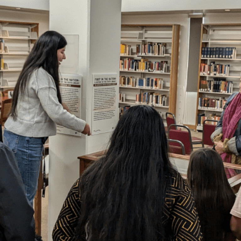 Image of Sandy Enriquez and attendees at the reception for the exhibit First in the Nation: A History of the Costo Library