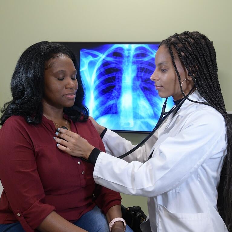 Medical student checking the heart of a patient