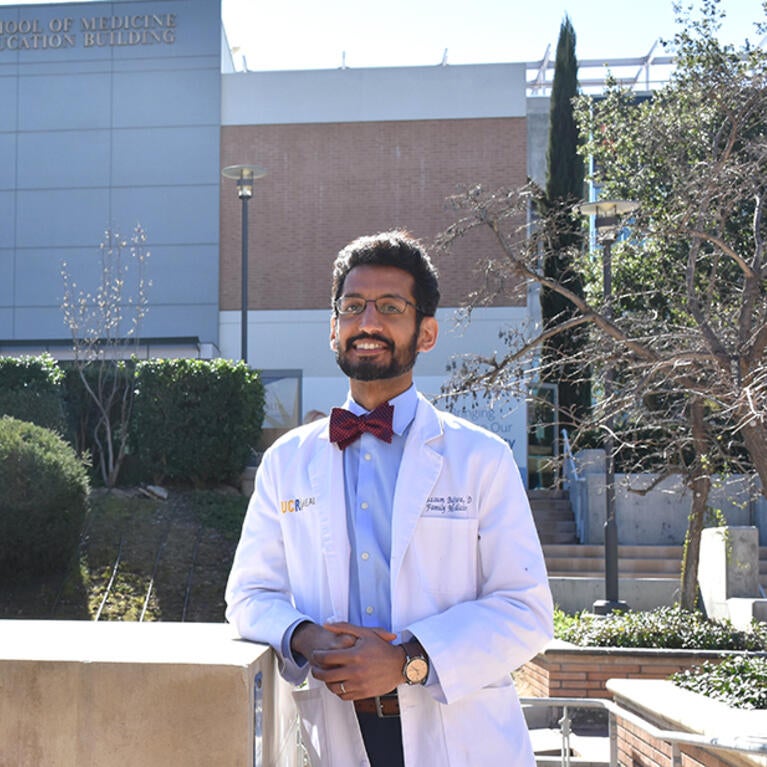 Moazzum Bajwa in front of the SOM Education Building
