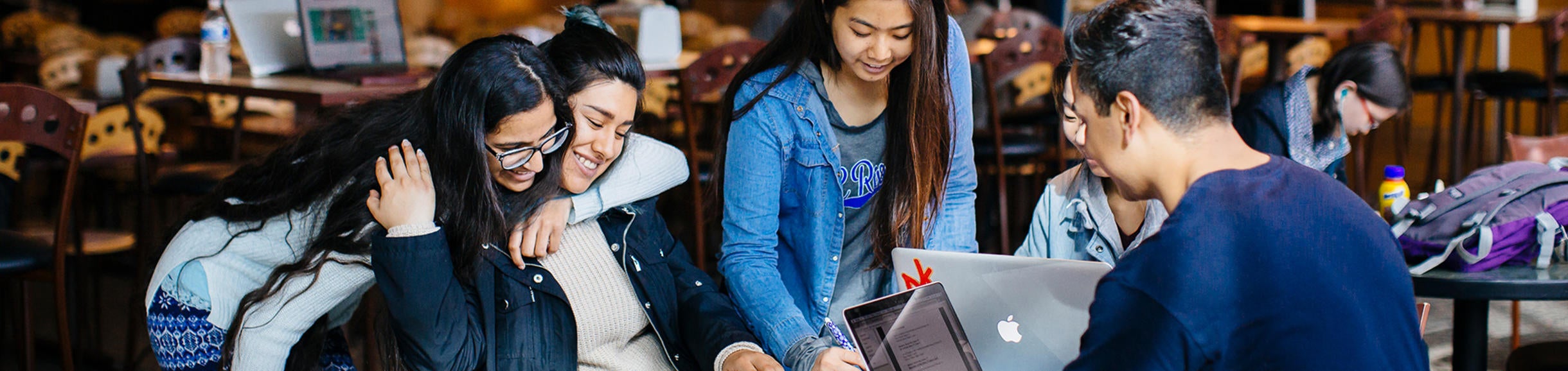students at a table working and smiling (c) UCR