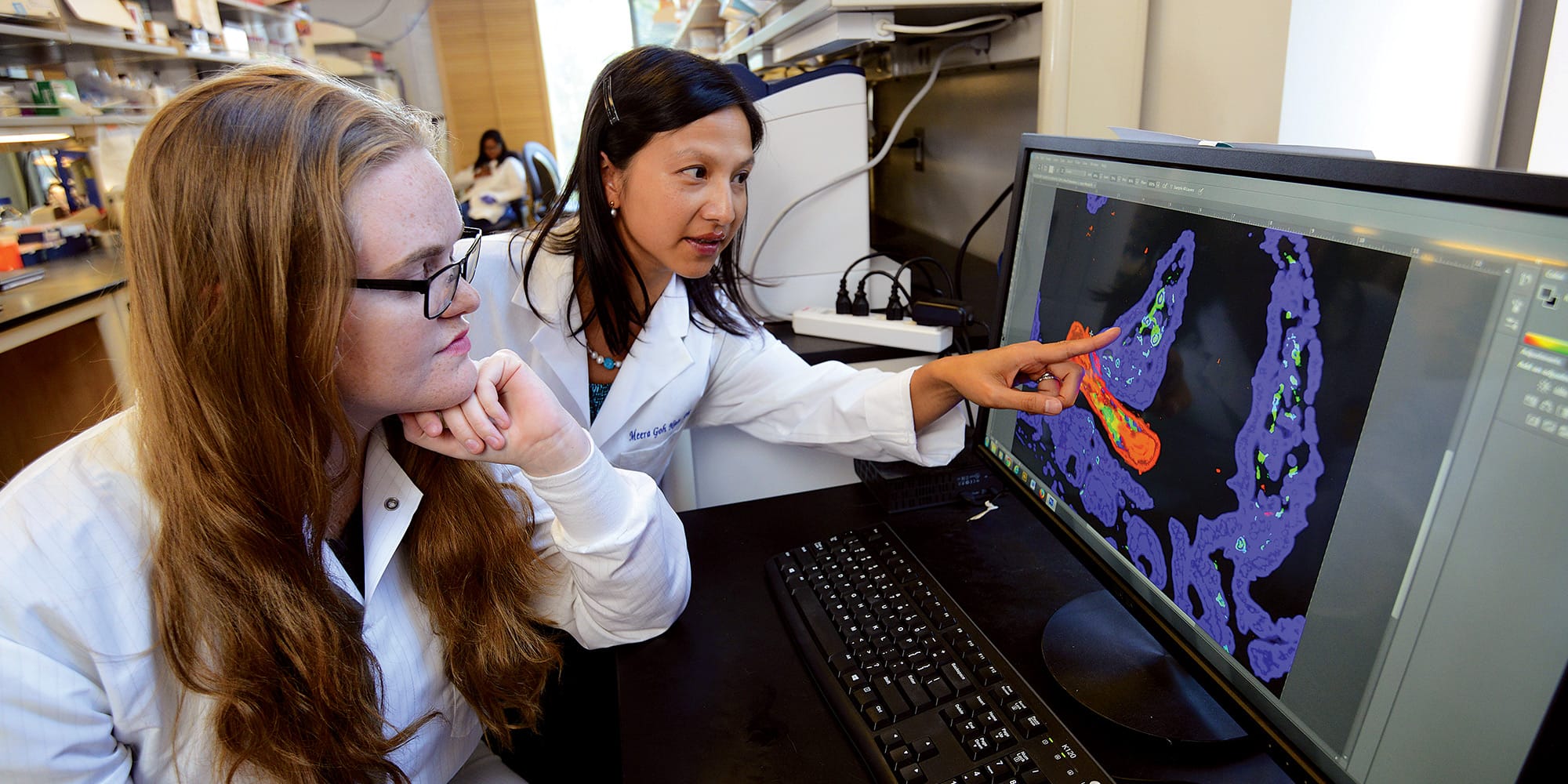 Biomedical sciences professor Meera Nair (right) with a student in her lab.