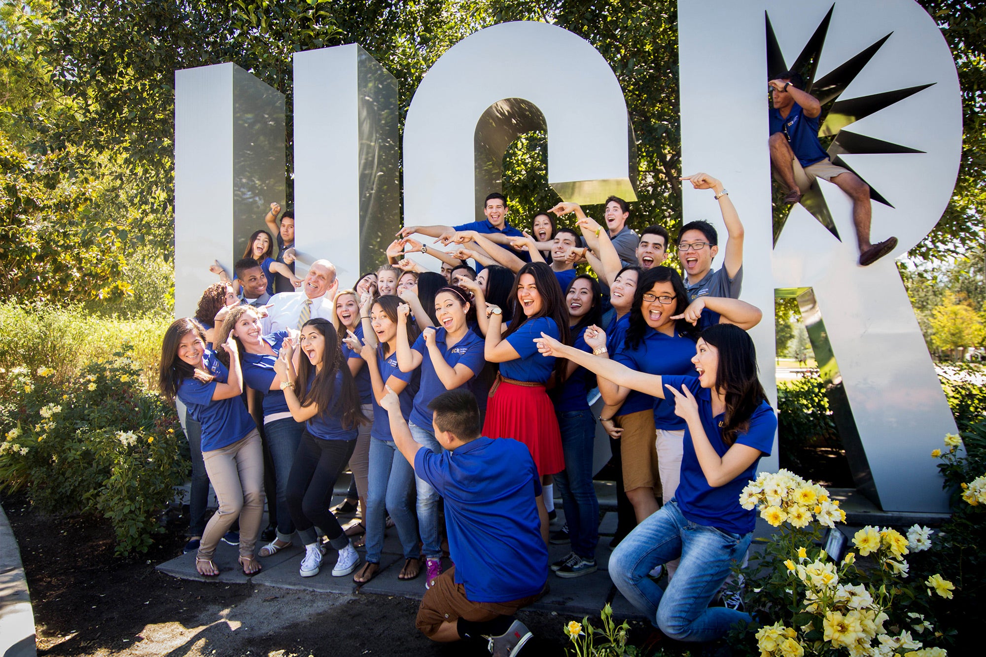 Wilcox takes a photo with student tour guides in front of the UCR sign in September 2013. (UCR/Q. Alan Dao)